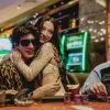 Jelenet az Anora című filmből, a képen egy férfi és egy nő ölelkezik egy kaszinó asztalánál